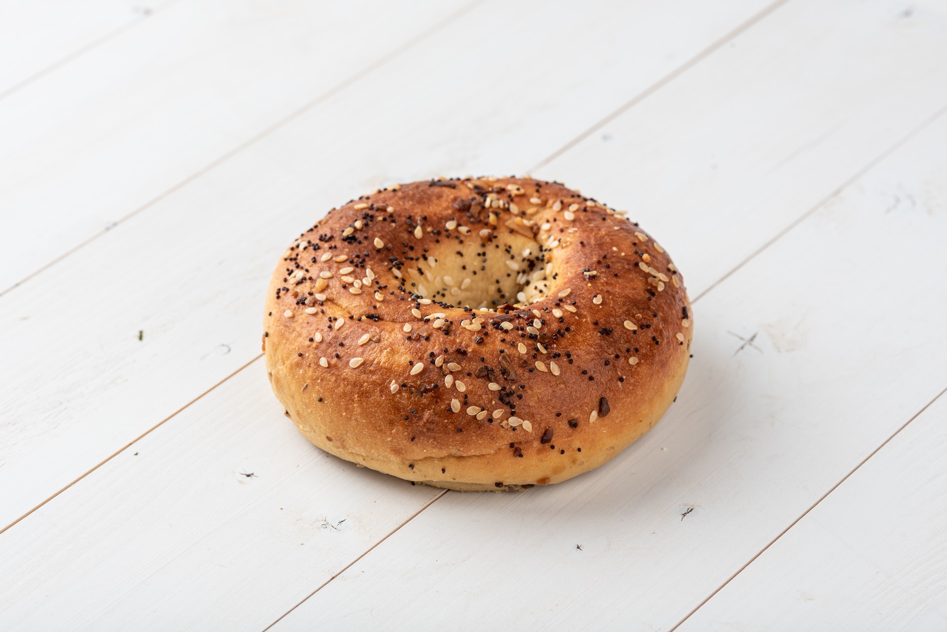 Perfect 10 Maxx Everything Protein Bagel on a wooden board.